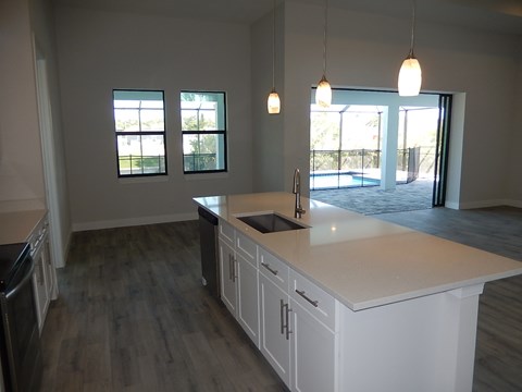 an open kitchen with a large counter top and a sink