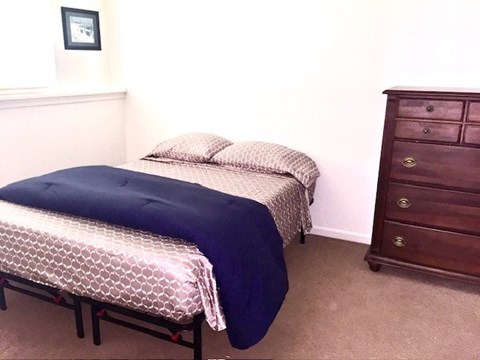 A bedroom with two beds and a dresser.