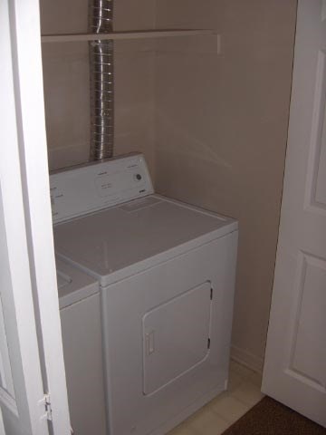 A white dryer and washer in a small laundry room.