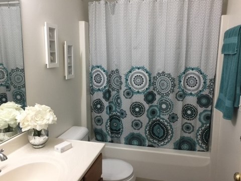 A white toilet sits next to a white sink in a bathroom.