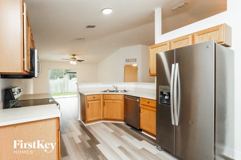 A kitchen with a stainless steel refrigerator and wooden cabinets.