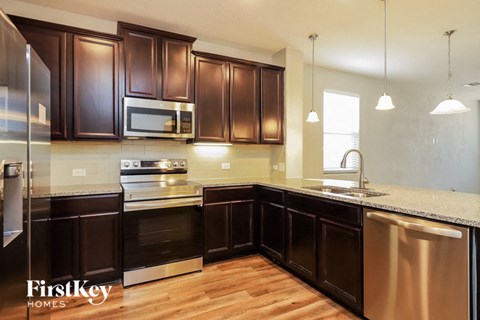 A kitchen with dark brown cabinets and stainless steel appliances.