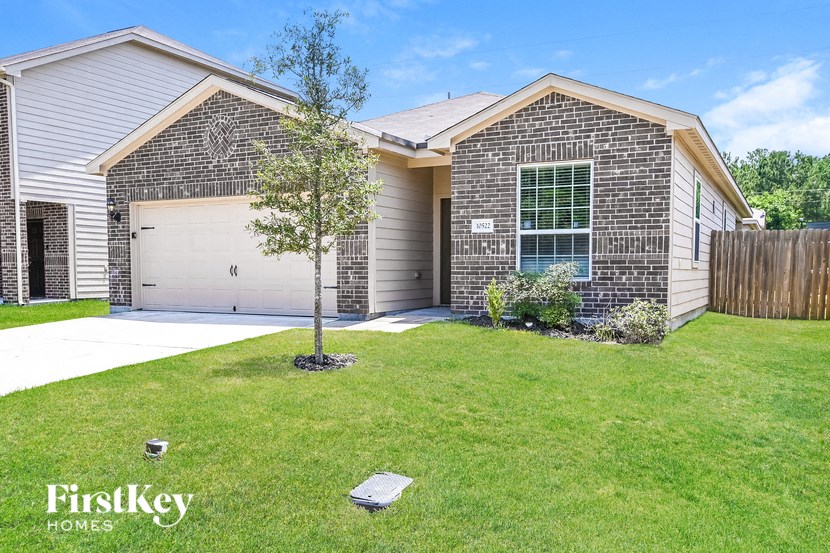 a house with a lawn and a tree in front of it