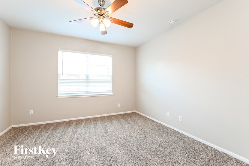 a bedroom with a ceiling fan and a window