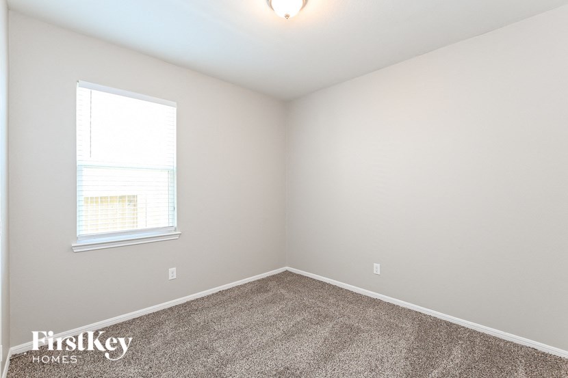 an empty room with carpet and a window