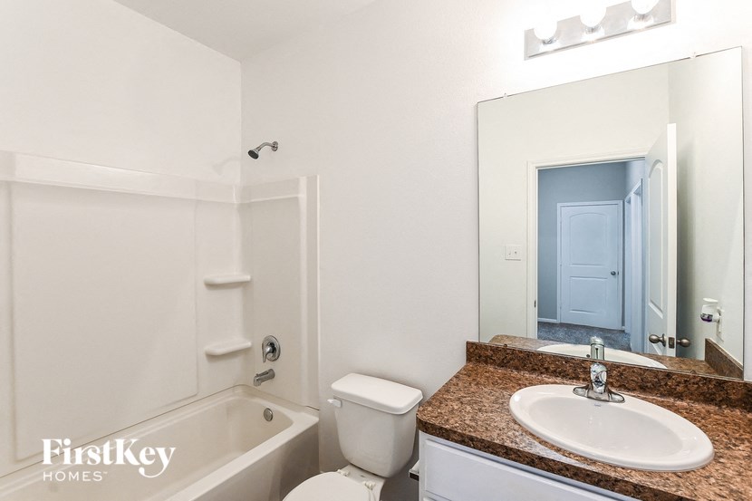 a white bathroom with a sink toilet and bath tub