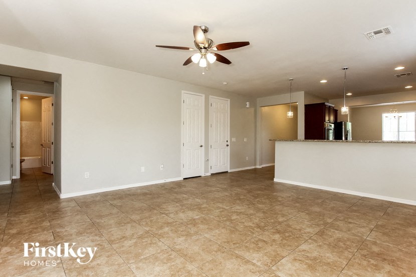 an empty kitchen and living room with a ceiling fan