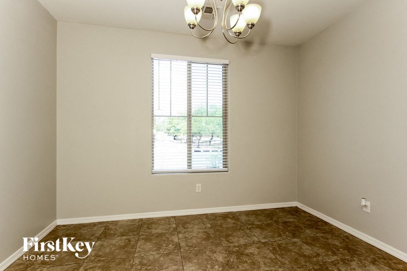 an empty living room with a window and a ceiling light