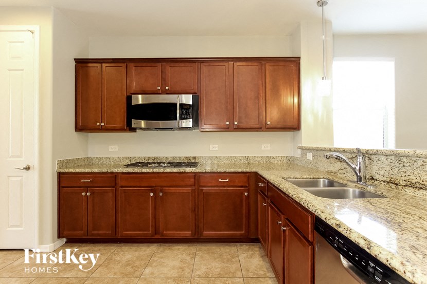a kitchen with granite counter tops and wooden cabinets
