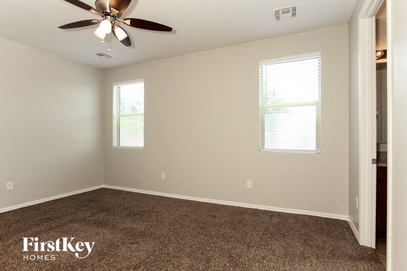 a empty room with a ceiling fan and a window