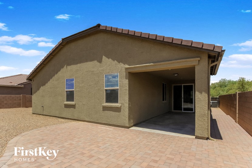 a home with a brick driveway and a brown house