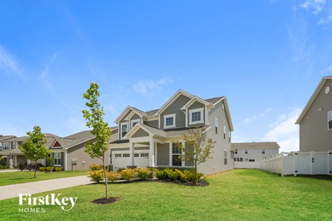 a house with a lawn and trees in front of it