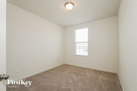 the living room of a home with a carpeted floor and a window