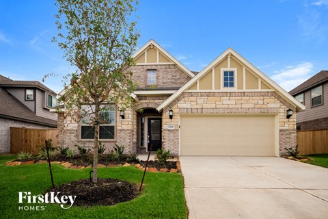 a house with a driveway and a tree in front of it