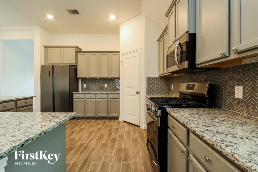 a kitchen with granite counter tops and stainless steel appliances