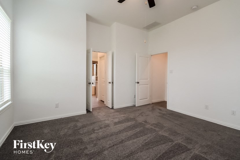 an empty living room with white walls and a gray carpet