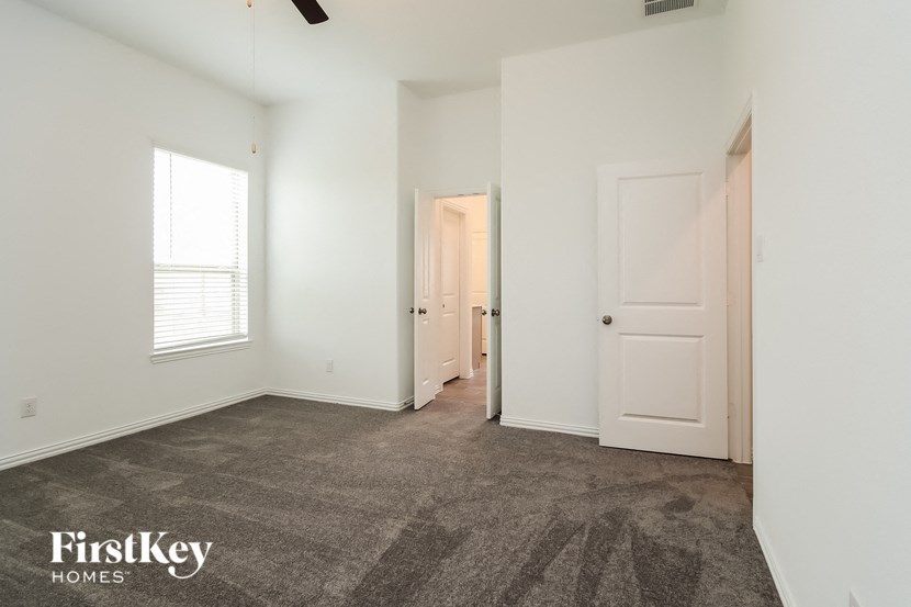 a bedroom with white walls and carpet and white doors