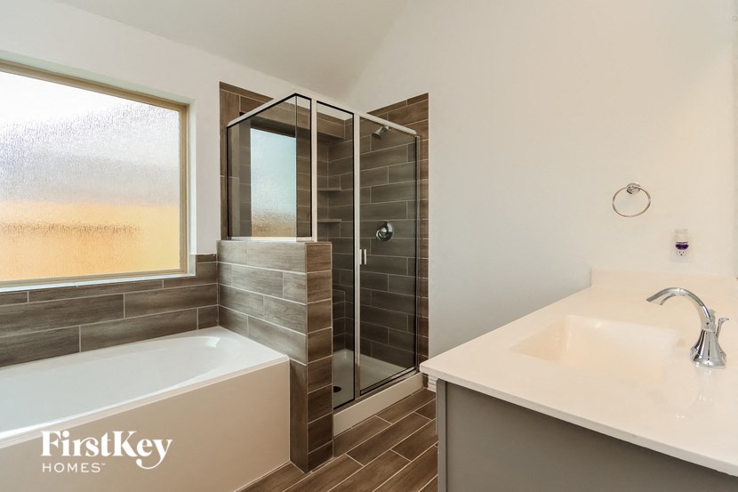 a bathroom with a tub and a shower and a sink