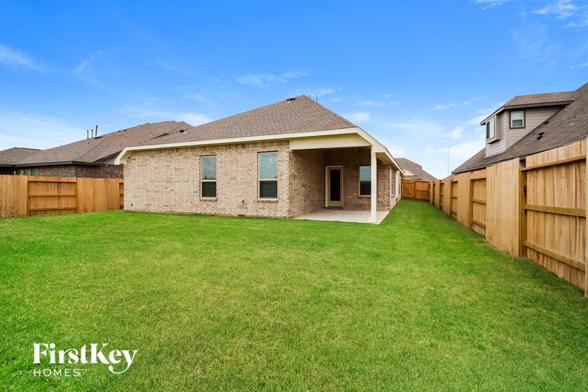 a backyard with a brick house and a wooden fence