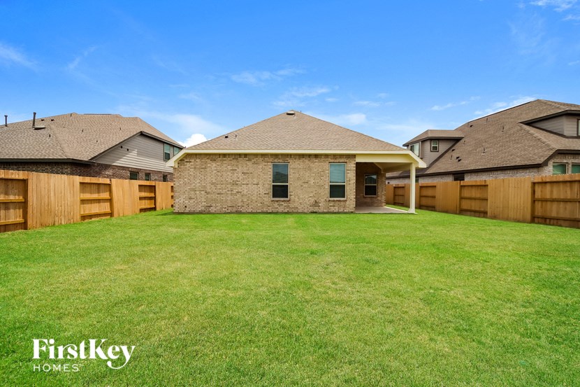 a backyard with a brick house and a wooden fence