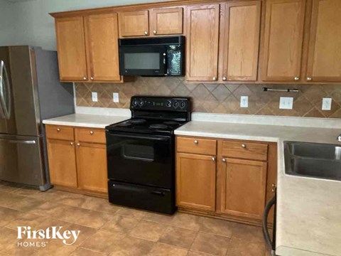 A kitchen with wooden cabinets and a black oven.