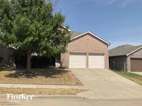 A brick house with a garage door is for sale.