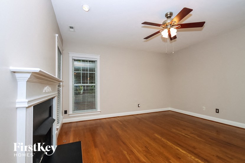 a living room with a fireplace and a ceiling fan