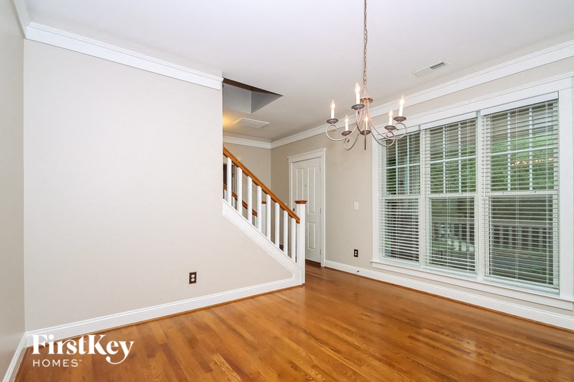 a renovated living room with a staircase and a large window