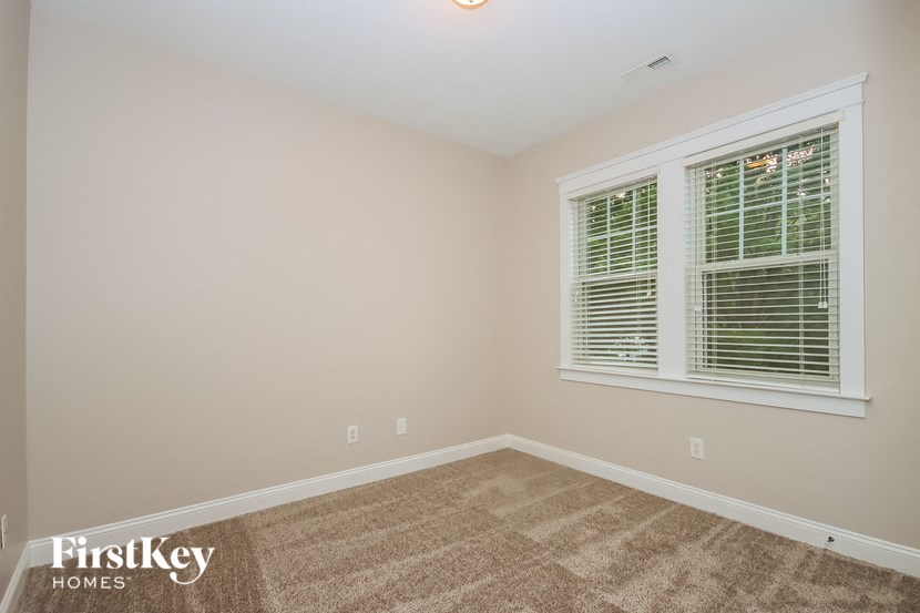 the second bedroom with carpet and two windows