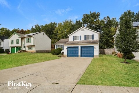 a white house with a blue garage door and a lawn