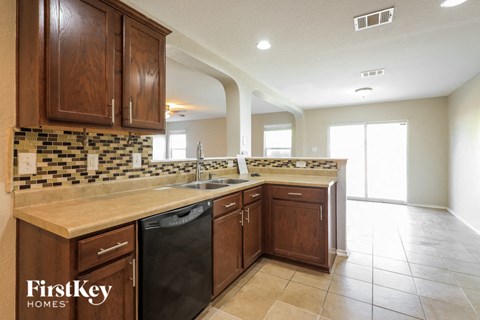 a kitchen with wooden cabinets and a dishwasher and a sink