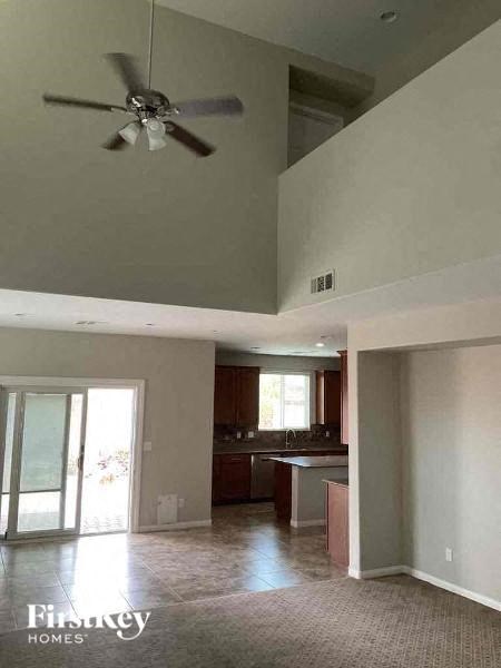 an empty living room with a ceiling fan