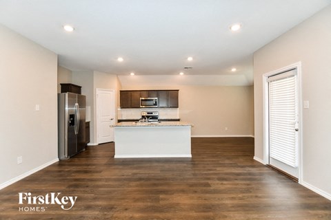 a kitchen with a white island and a stainless steel refrigerator