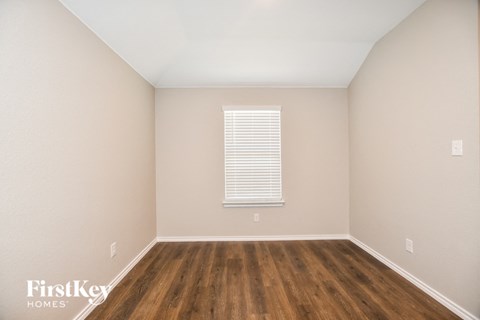 the living room of a home with wood floors and a window