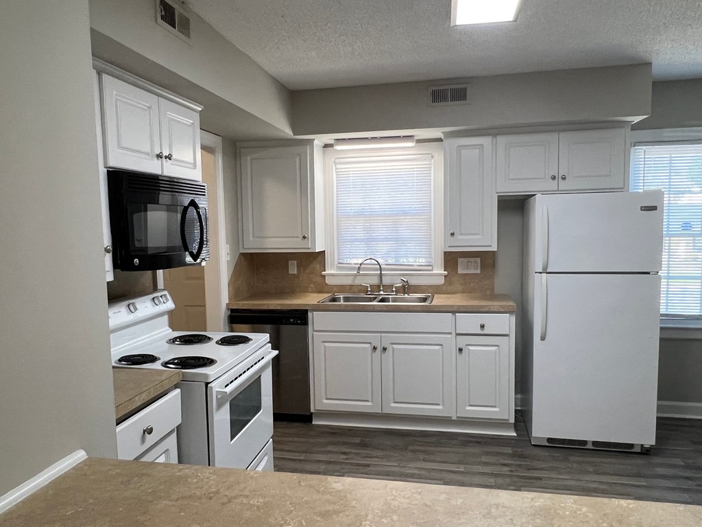 A kitchen with white cabinets and appliances.