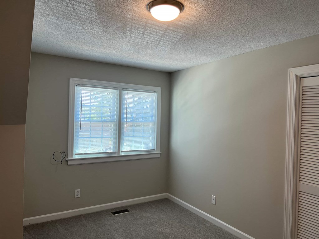 A room with a window and a ceiling light.