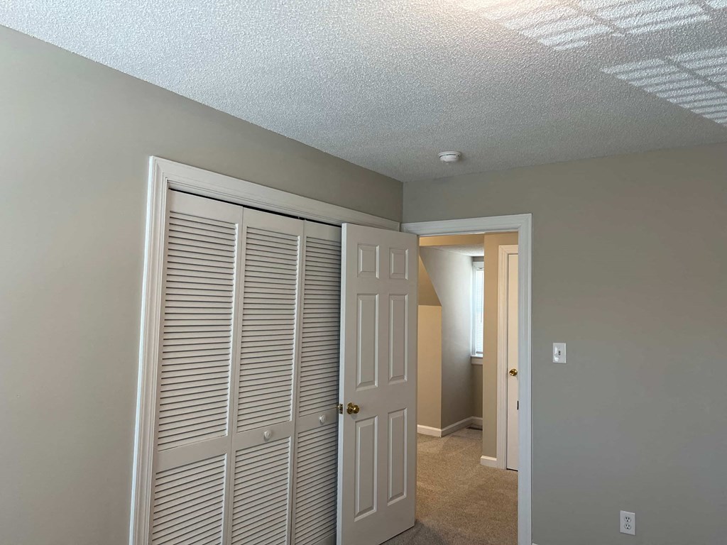 A room with a white door and a white closet door.