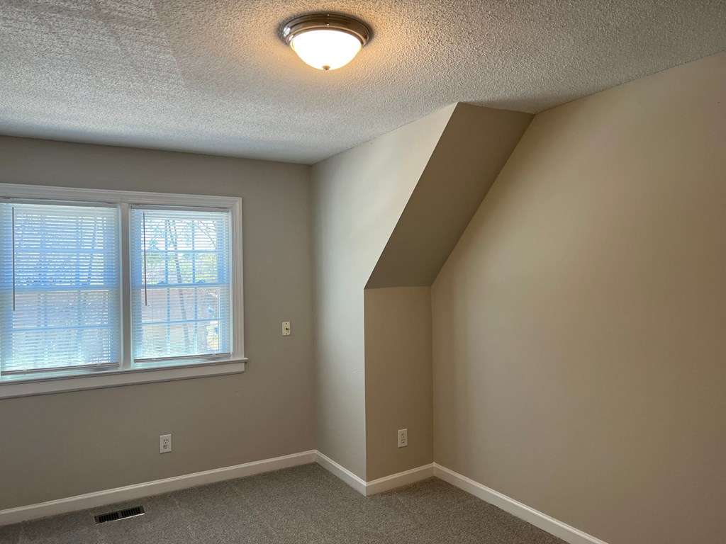 A room with a window and a light on the ceiling.