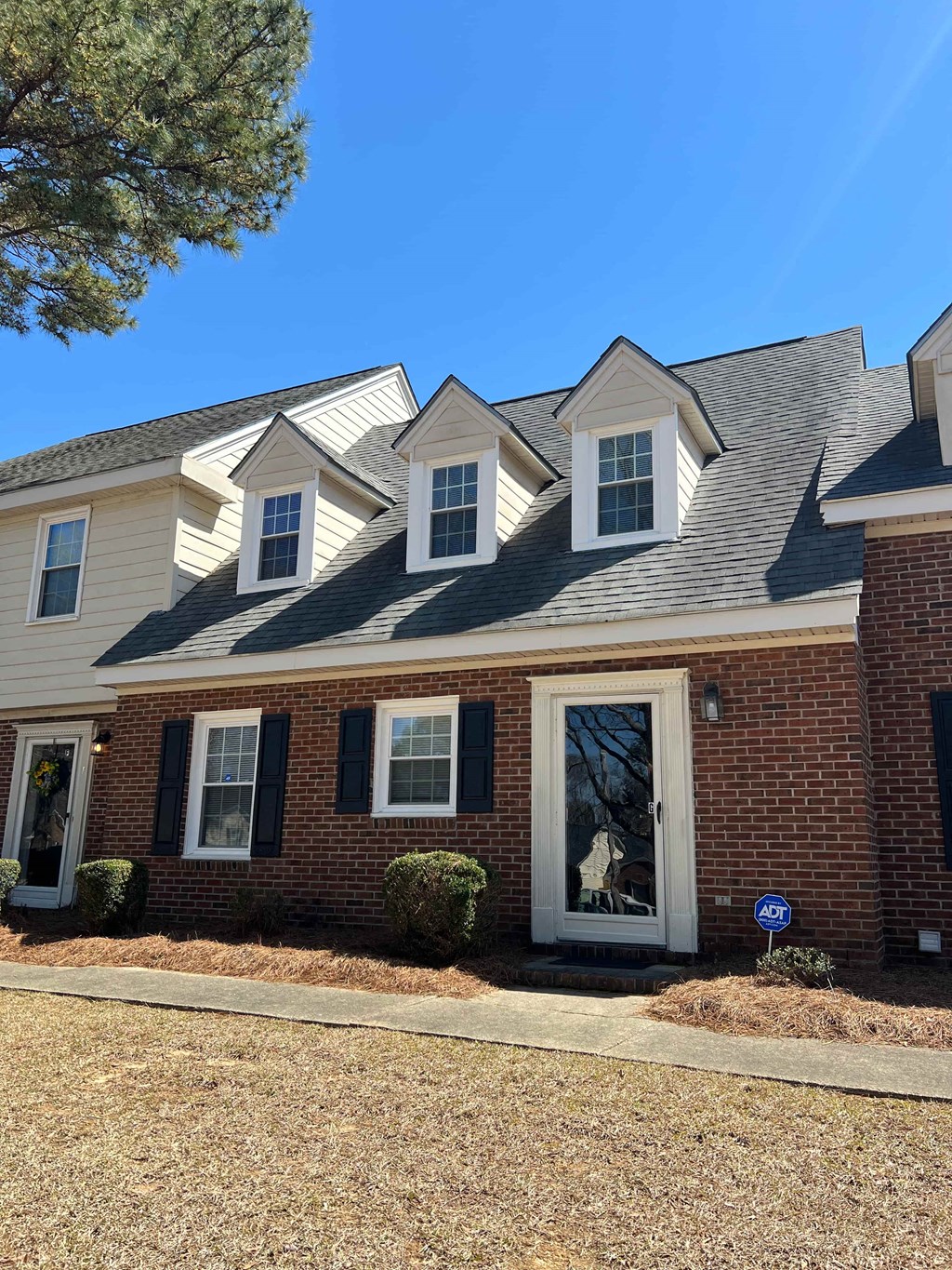 A house with a white door and black shutters.
