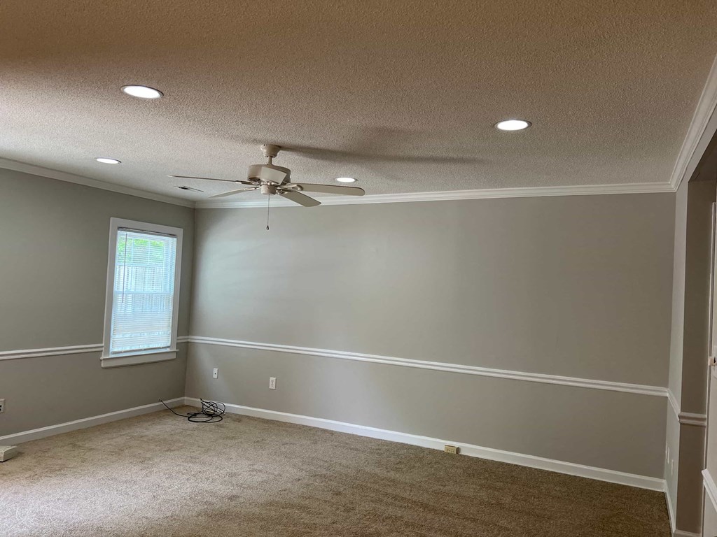 A room with a ceiling fan and a window.