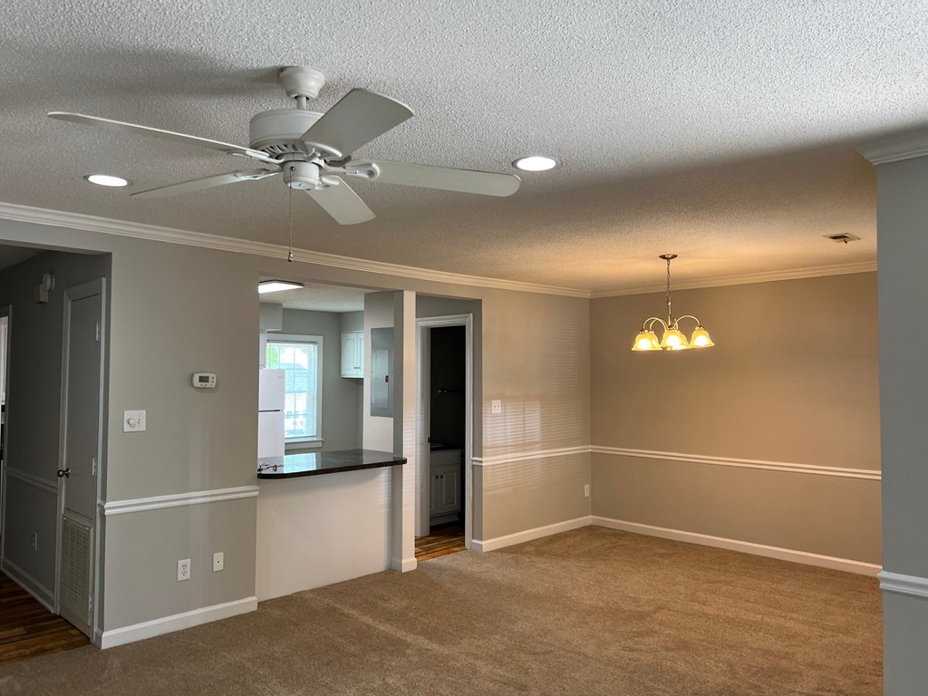 A room with a ceiling fan and a chandelier.