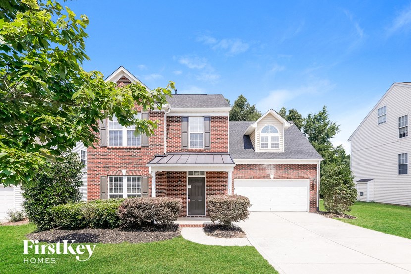 a brick house with a white garage door and a lawn