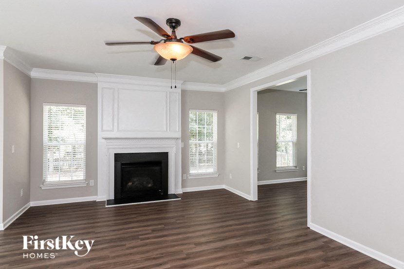 a living room with a fireplace and a ceiling fan
