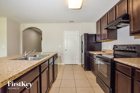 A kitchen with brown cabinets and a sink.