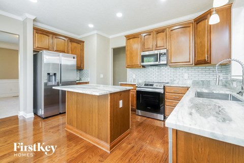 A kitchen with wooden cabinets and a marble countertop.