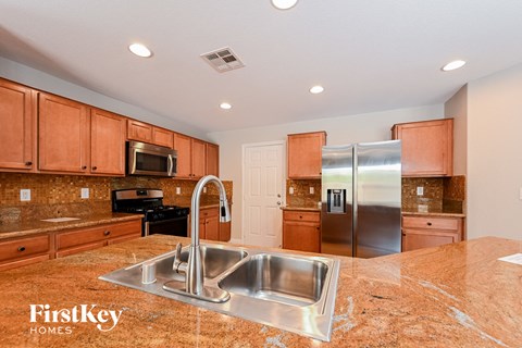 a kitchen with a sink and a stainless steel refrigerator