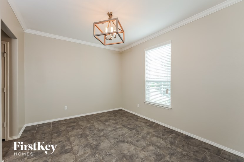 A room with a light fixture and a window with blinds.
