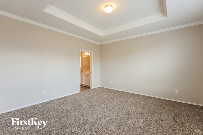 A room with a carpeted floor and a door in the middle of the wall.