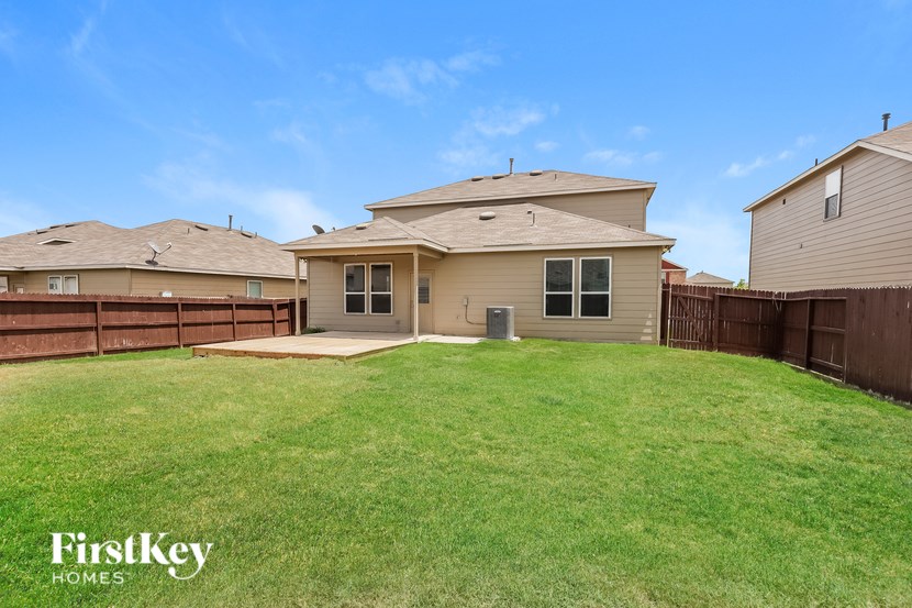 A house with a brown roof and a fence in the front yard.