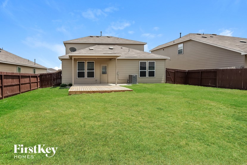 A house with a brown fence and a green lawn.